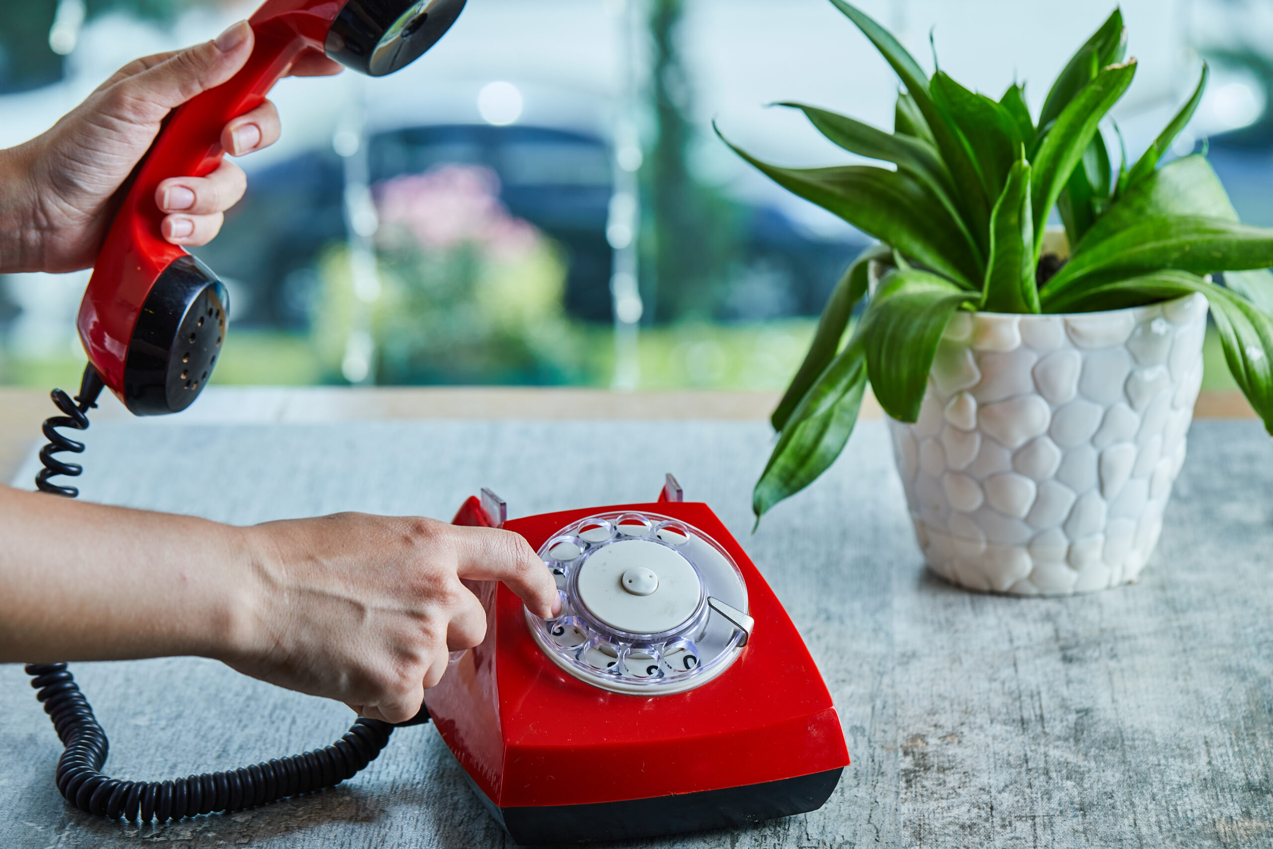 Hand dialing the number on telephone in the marble background. High quality photo